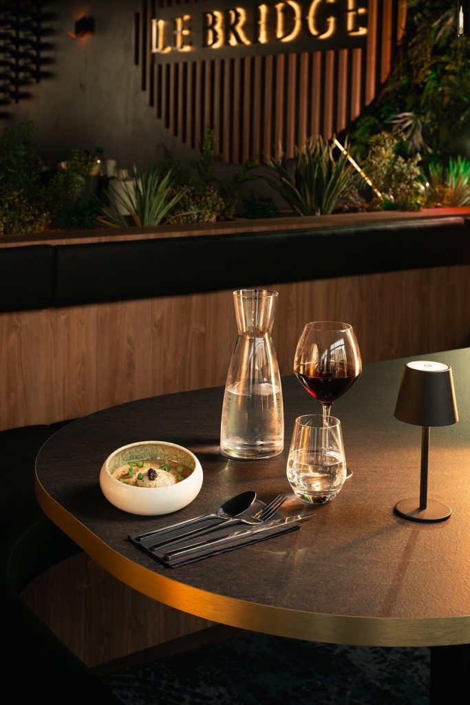 Table d'un restaurant chic avec dîner, vin rouge et carafe d'eau